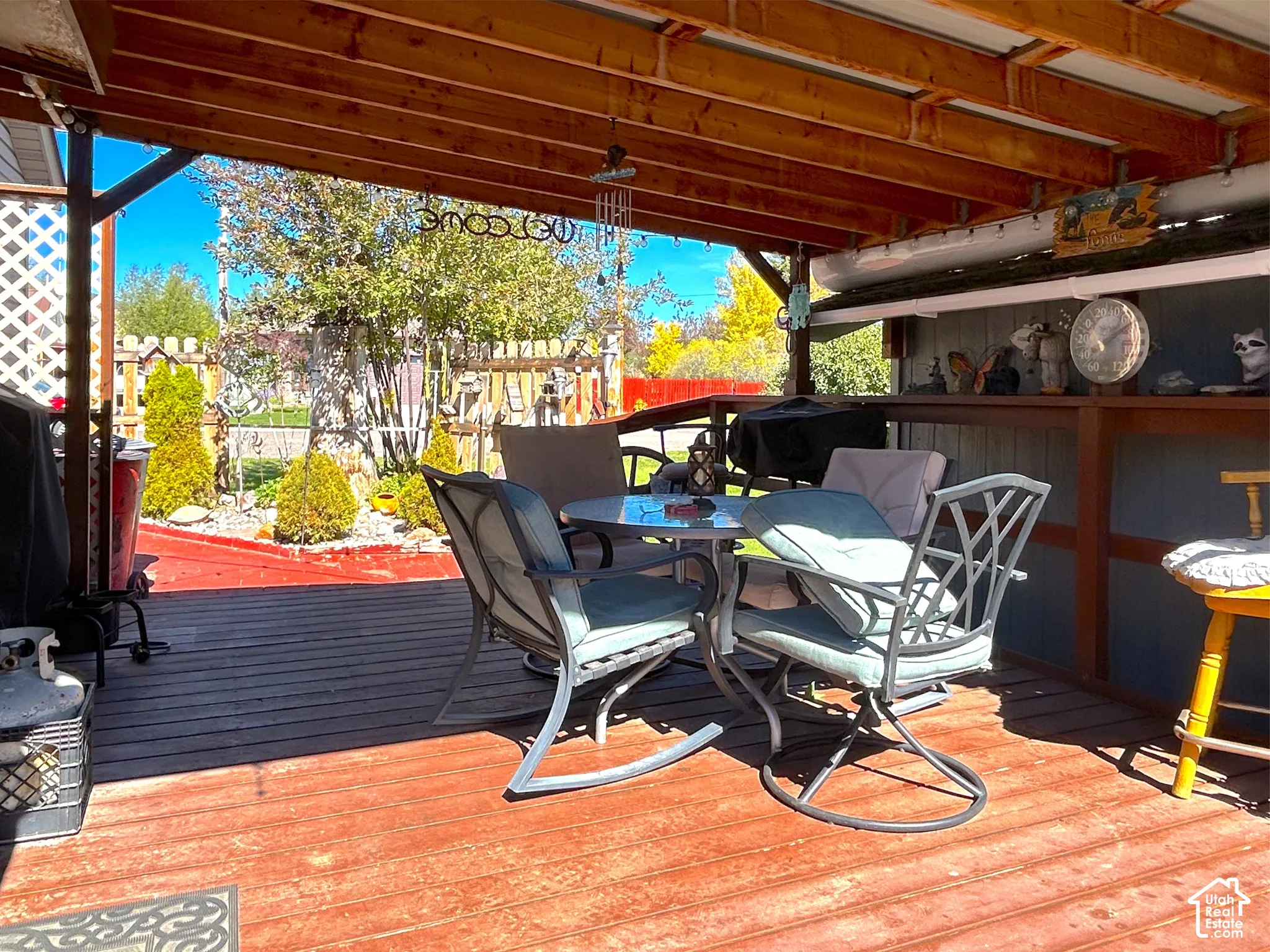 Covered wood deck with exposed wood beams and a lattice privacy screen