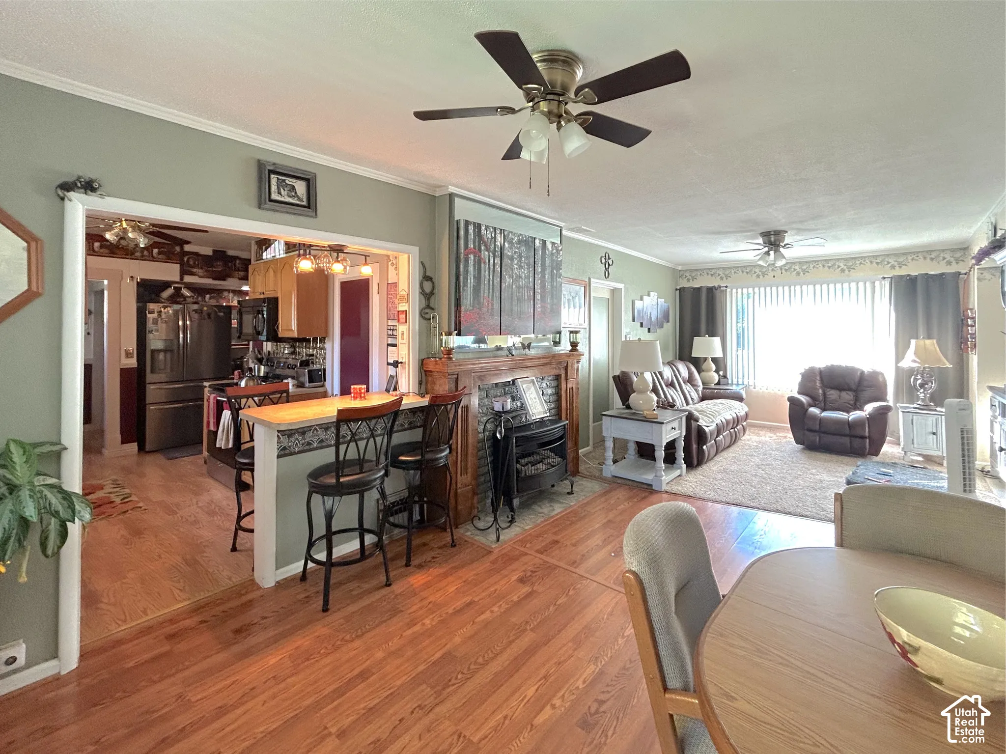 Wood-finish flooring throughout, with a built-in breakfast bar featuring a light-colored countertop