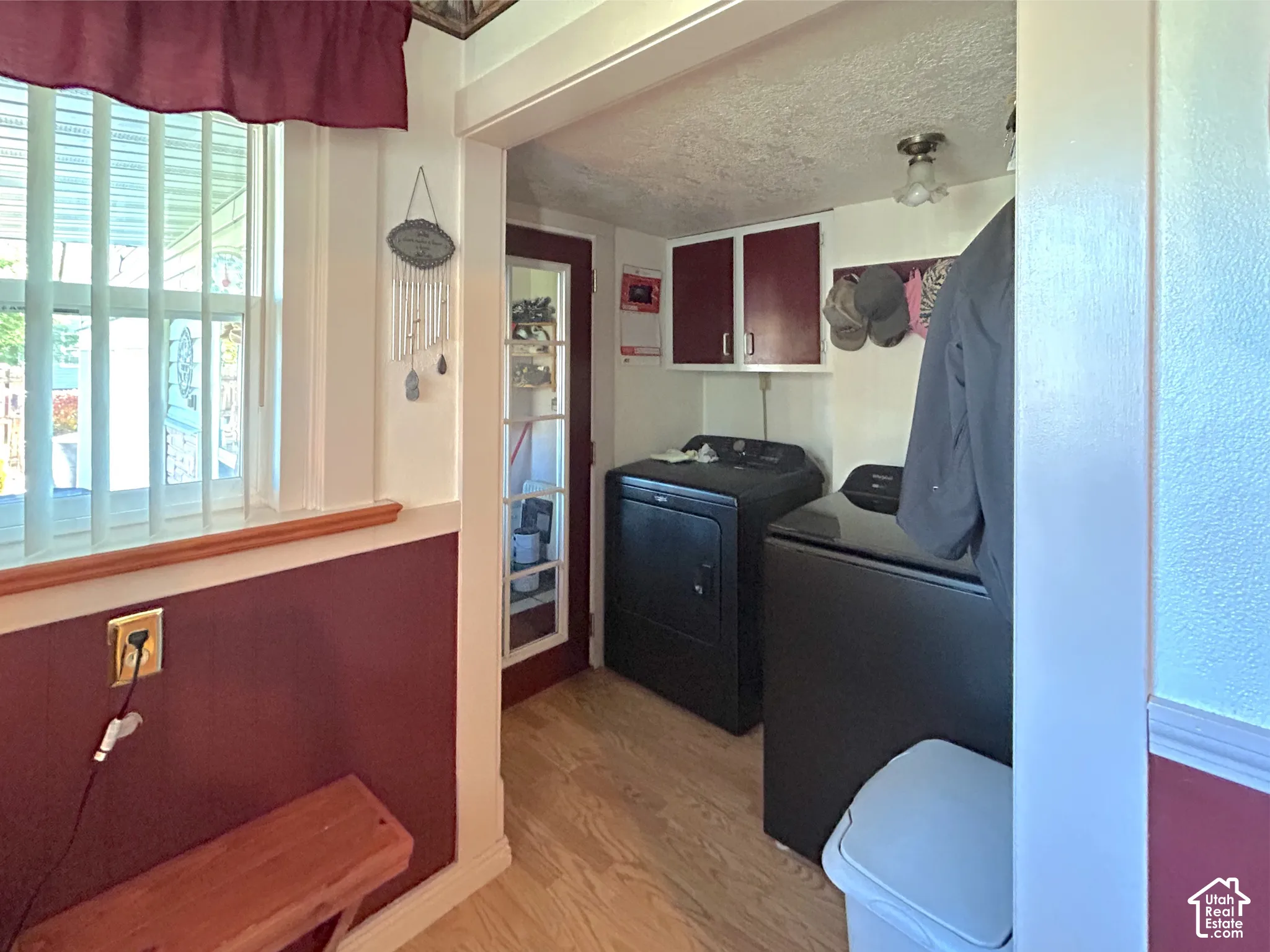 Wood-finish flooring with wall-mounted cabinetry in the mud room/laundry area.