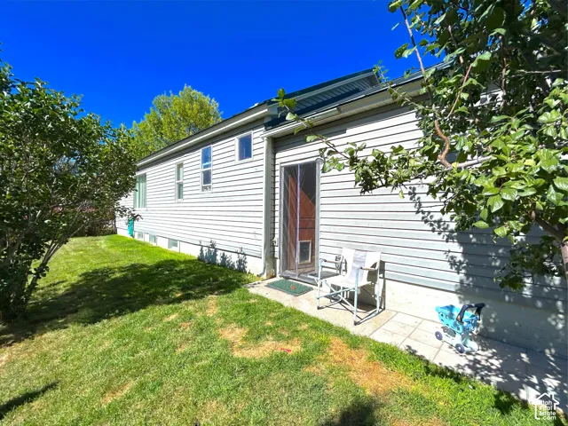 Side exterior with horizontal siding, multiple windows, and direct patio access