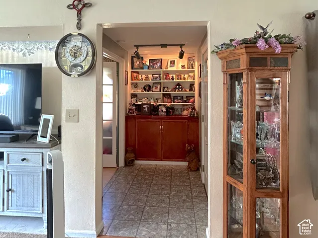 Wood-finish flooring, cased doorway, recessed lighting, and built-in shelving