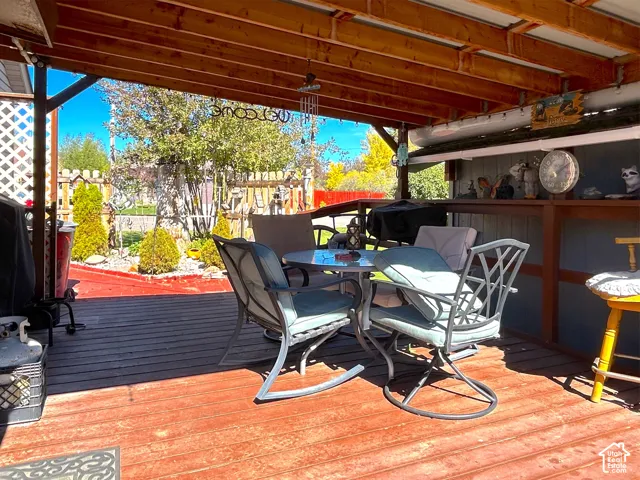 Covered wood deck with exposed wood beams and a lattice privacy screen