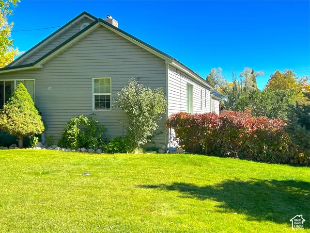 Gabled roofline with dark green trim, light gray siding exterior, and a prominent chimney