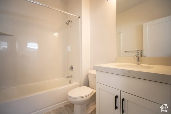 Full secondary bath with painted white wood cabinets and quartz slab countertops.