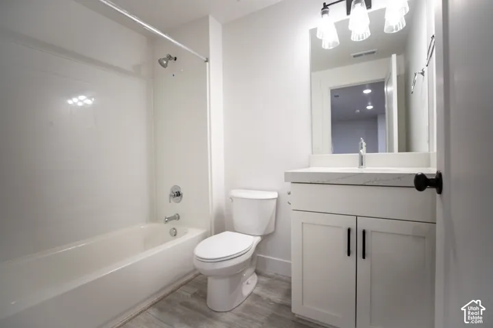 Third full bathroom with painted white wood cabinets and quartz slab countertops.