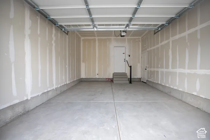 One car garage with additional space for storage and taped finish.