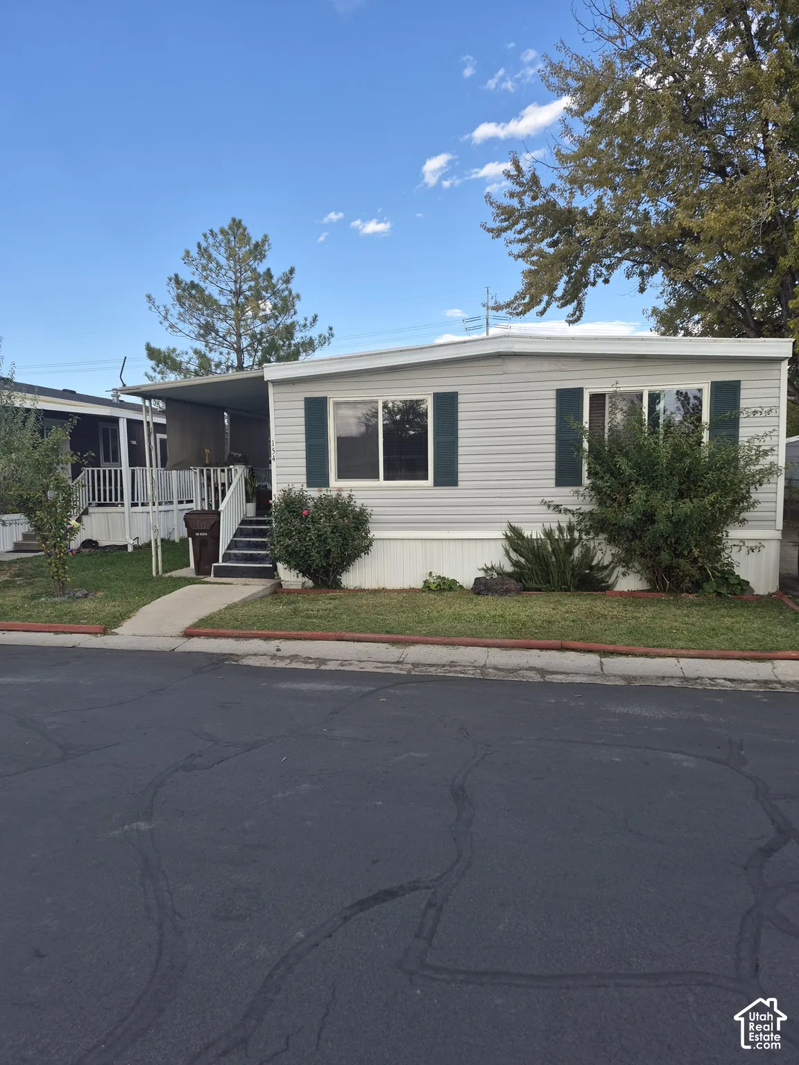 Light-colored siding exterior with dark green shutters