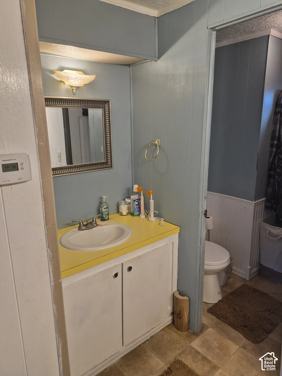 Vanity with a yellow countertop, white sink, and cabinet storage