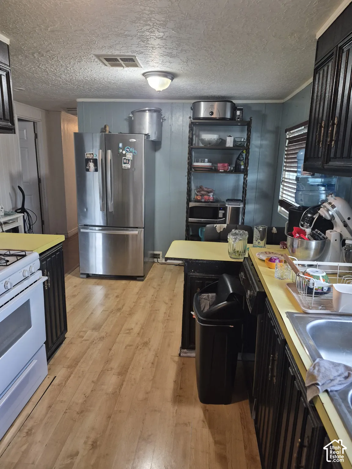 Wood-finish flooring with black cabinetry and yellow countertops