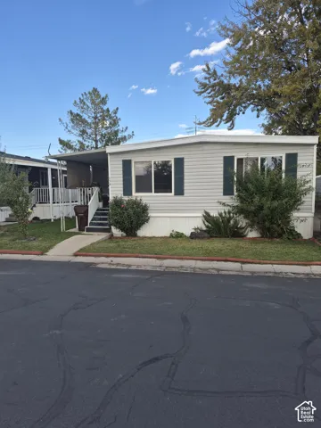 Light-colored siding exterior with dark green shutters