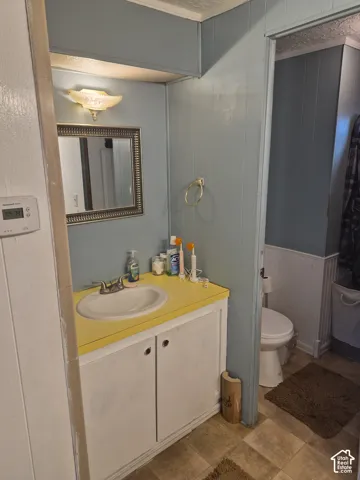 Vanity with a yellow countertop, white sink, and cabinet storage
