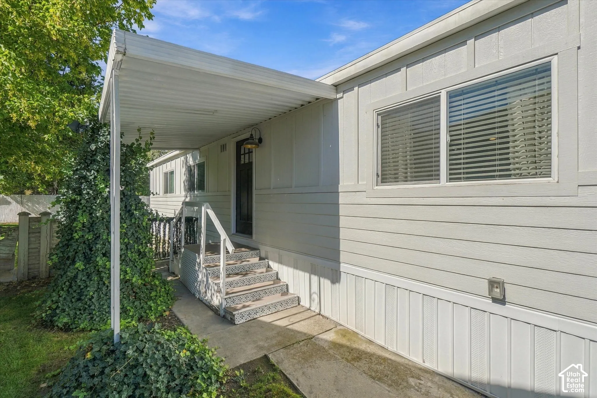 Covered entryway with steps featuring decorative risers and a dark paneled door