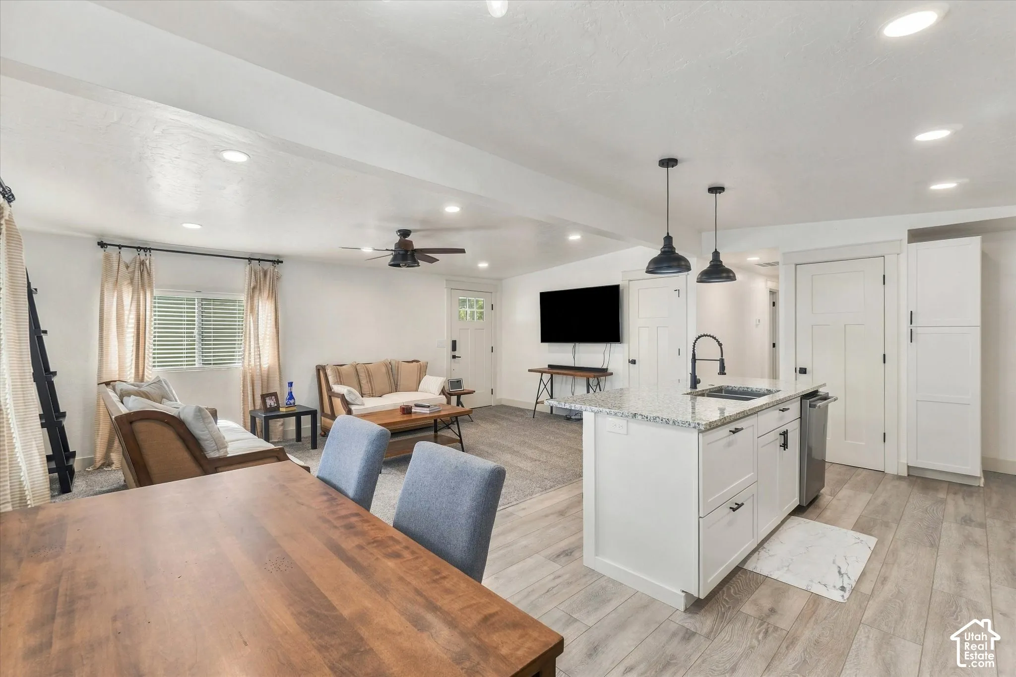 Open-concept living space with wood-finish flooring, recessed lighting, and a ceiling fan