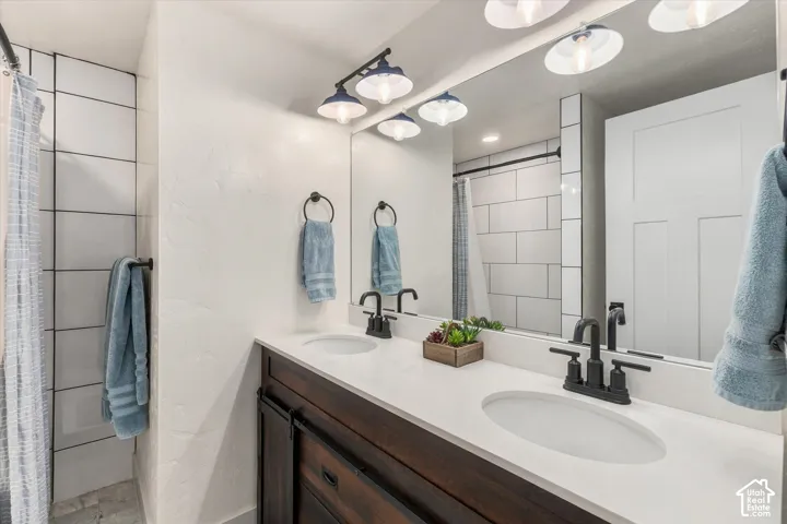 Dual vanity with integrated sinks, white countertop, and dark wood-finish cabinetry