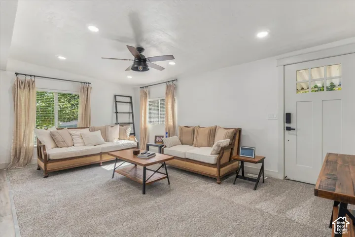 Recessed lighting, ceiling fan, wood-finish flooring, white paneled door with glass inserts, and broad windows