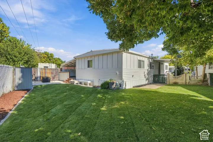 Expansive lawn area with a chain link fence and wood chip border