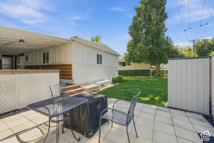 Expansive outdoor patio with concrete pavers and a covered porch