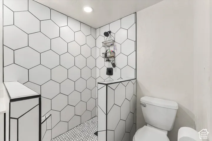 Shower stall featuring hexagonal wall tiling and a complementary hex-tiled floor