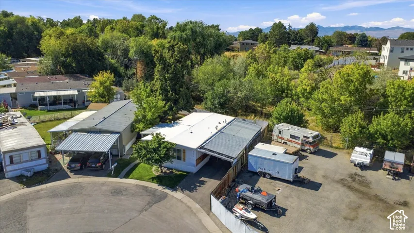 Property with two distinct rooflines, a carport, and an expansive gravel parking area