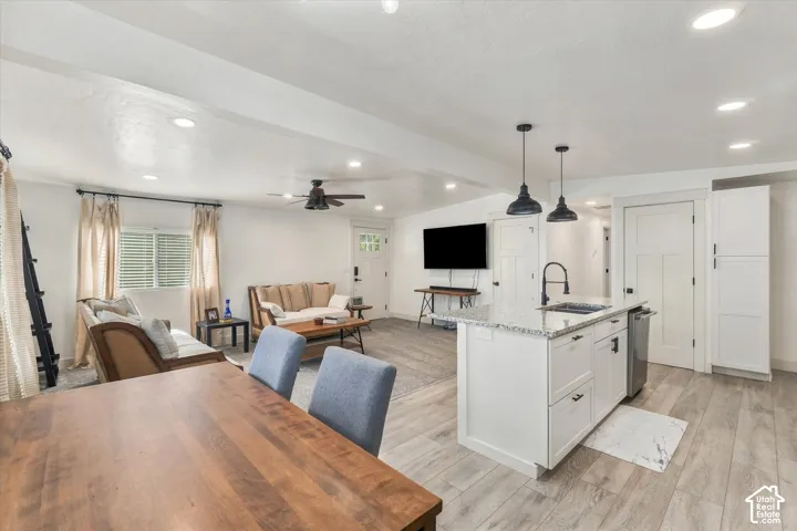 Open-concept living space with wood-finish flooring, recessed lighting, and a ceiling fan