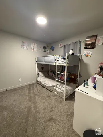Recessed ceiling lighting illuminates a room with light gray wall paint and gray carpeting
