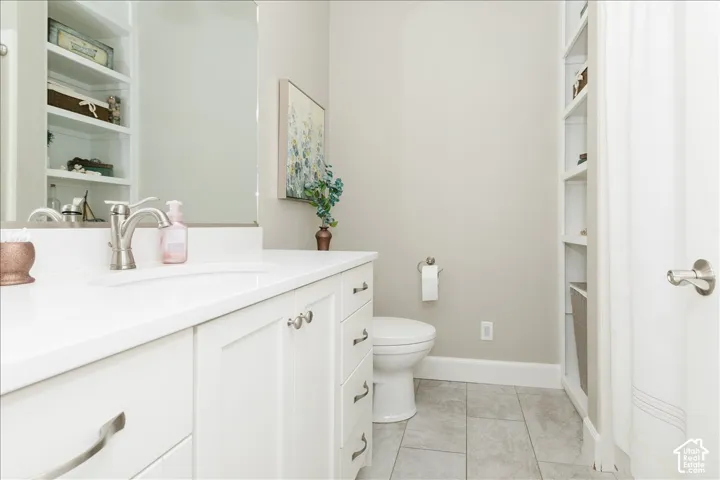White vanity with brushed nickel hardware, integrated sink, and a large mirror