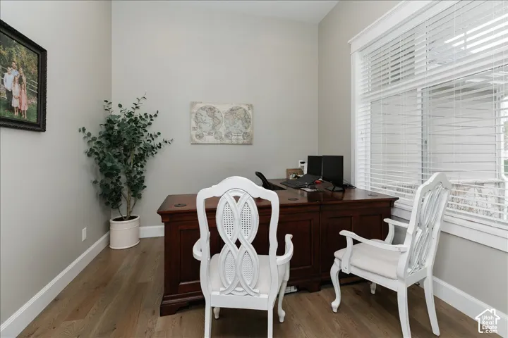 Wood-finish flooring, light gray wall paint, and a window with white blinds