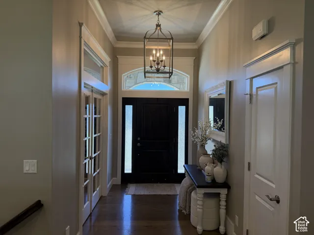 Hardwood-finish flooring, crown molding, double French doors, transom windows, and a built-in light fixture
