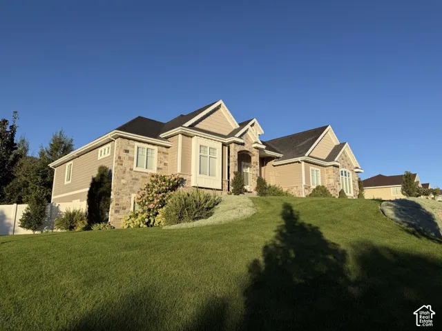 Stone and siding exterior with dark shingle roof