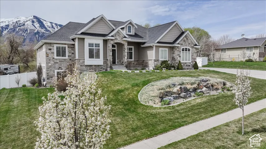 Stone and siding exterior with a dark shingle roof