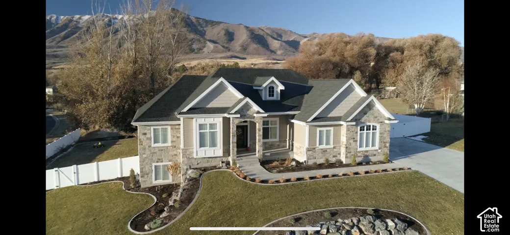 Stone and siding exterior with a dark shingle roof