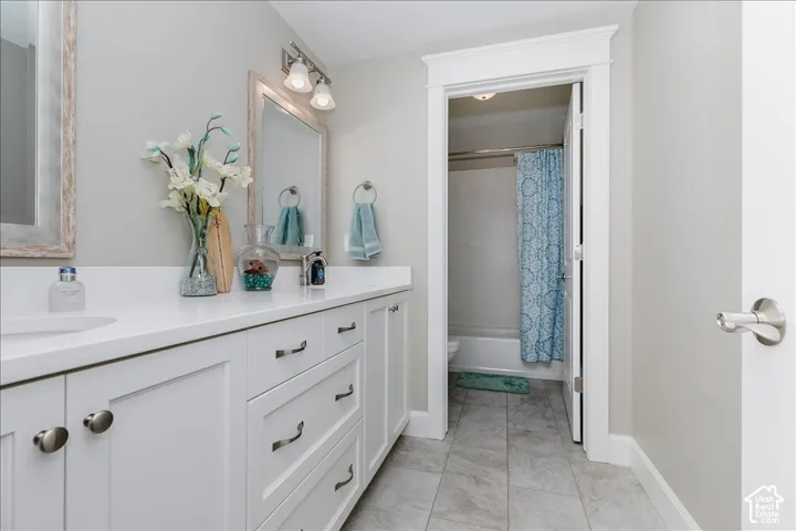 Dual vanity with white cabinetry and integrated sinks, complemented by light-toned countertops