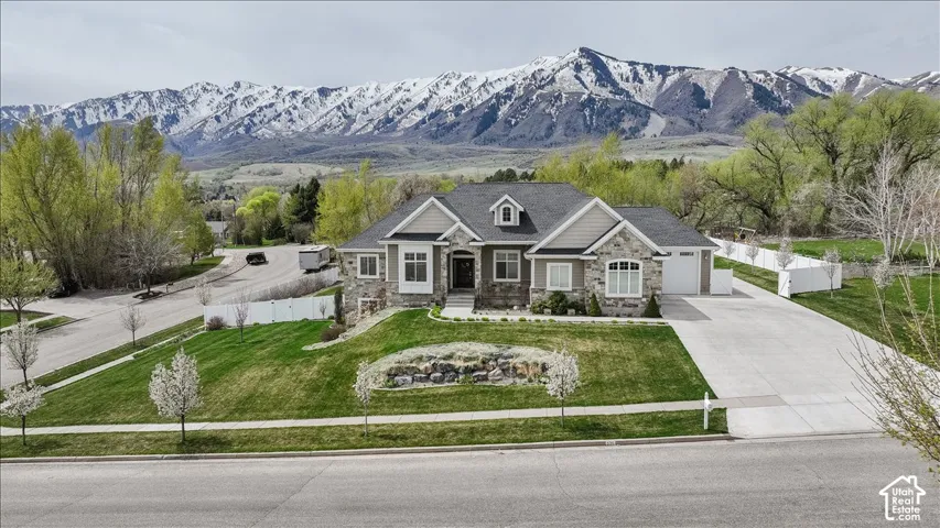Stone and siding exterior with a prominent front entrance, an attached two-car garage, and a concrete driveway
