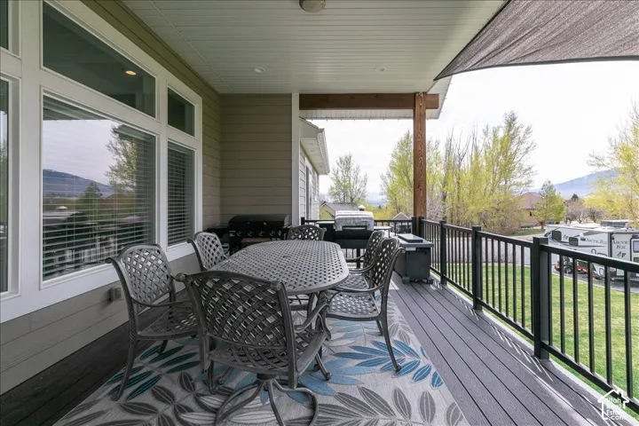 Covered outdoor deck with composite decking, white soffit ceiling, and black metal railings