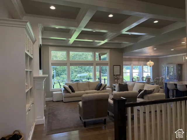 Coffered ceiling with recessed lighting, integrated built-in shelving, fireplace with mantel, and wood-finish flooring