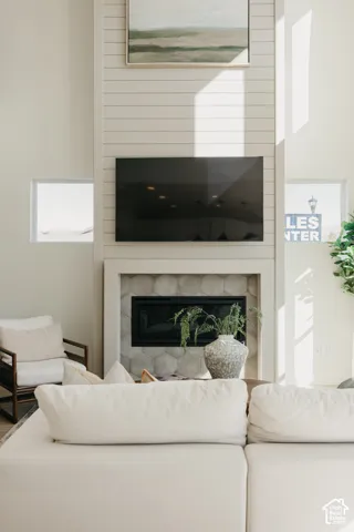 Fireplace with hexagonal tile surround, built-in television, and shiplap accent wall