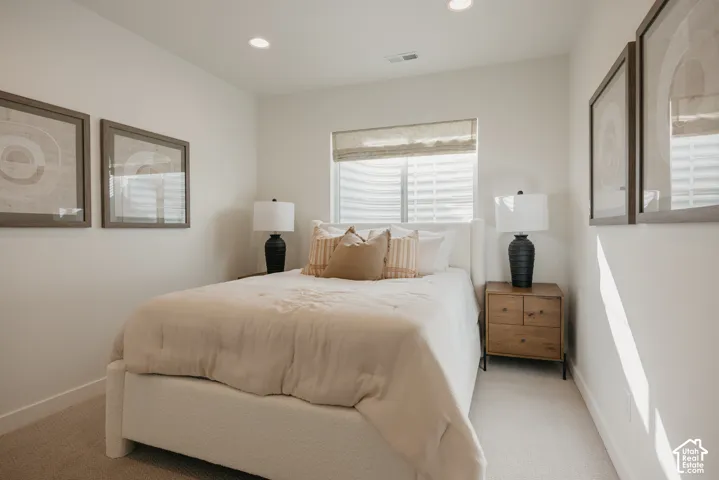 Recessed ceiling lighting, window with blinds, carpeted flooring, and a built-in closet