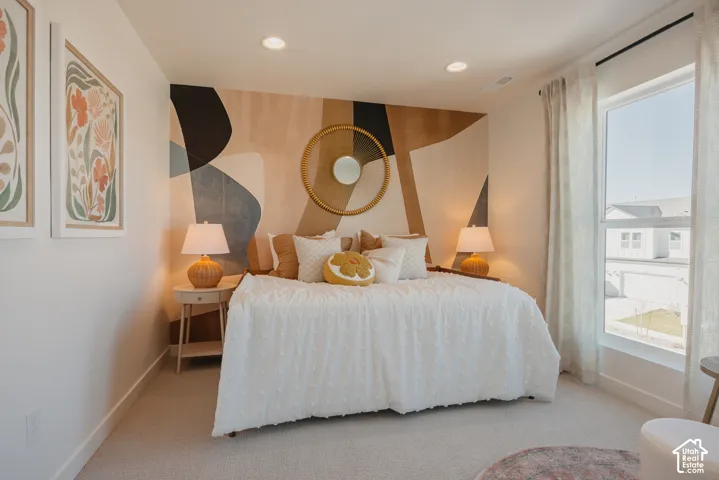 Recessed lighting, large window with ample natural light, neutral carpeting, and a decorative accent wall