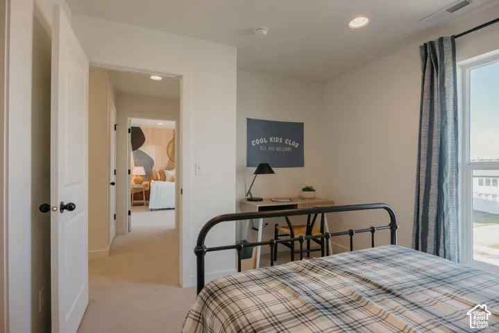 Recessed ceiling lighting, light-toned wall paint, carpeted flooring, and a window with vertical blinds