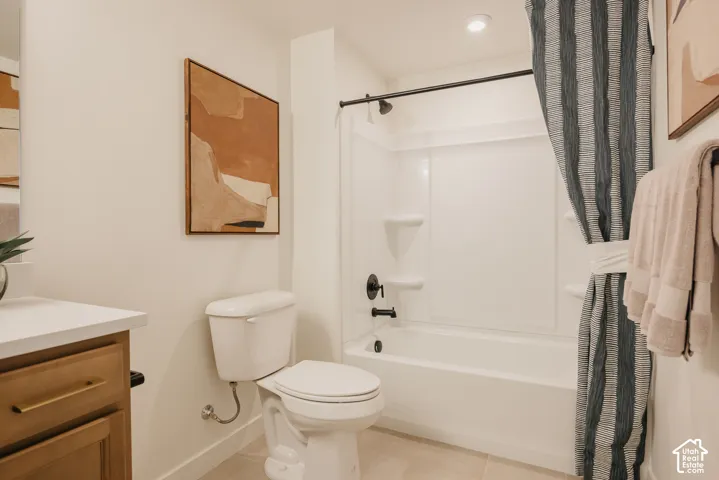White bathtub with black fixtures and a shower head, set against a white surround