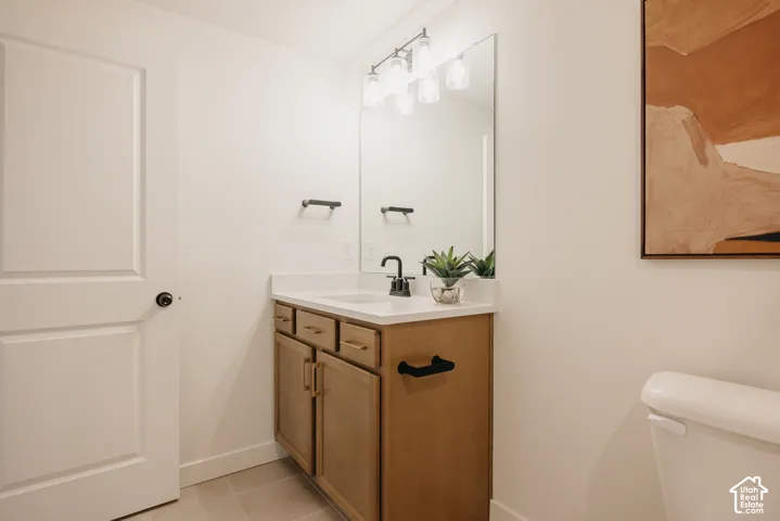 Custom wood-finish vanity with gold-tone hardware, white countertop, and integrated sink