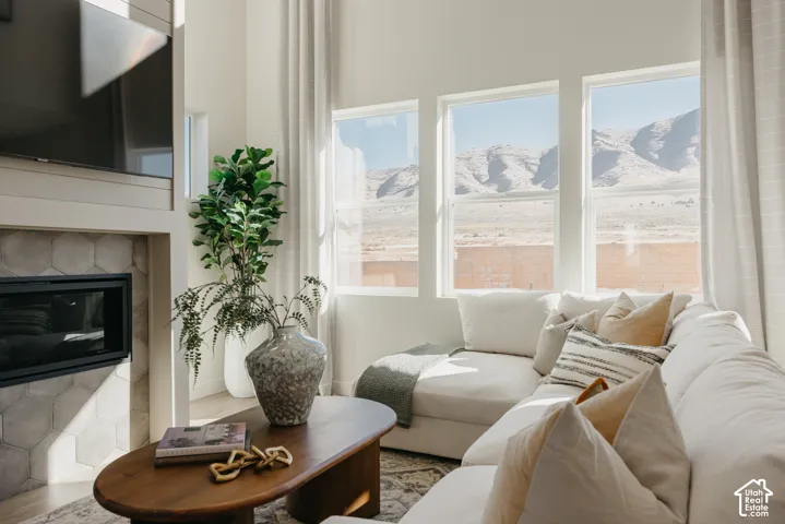 Fireplace with hexagonal tile surround, multiple large windows, and high ceilings