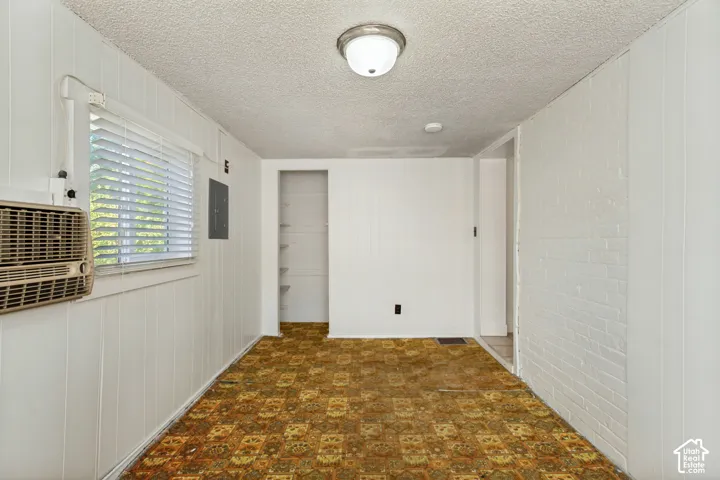 White paneled walls with a window, built-in shelving, and patterned carpet flooring