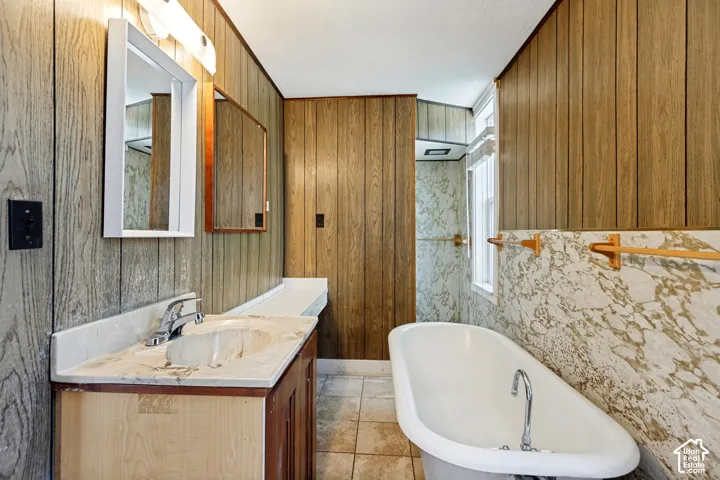 Vanity with integrated sink and chrome faucet, flanked by vertical wood-paneling walls