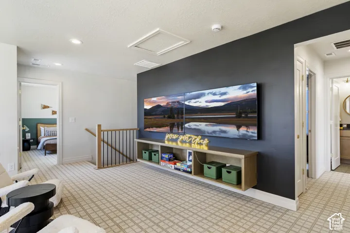 Wall-mounted media console with built-in shelving, dark accent wall, and light-toned patterned carpet