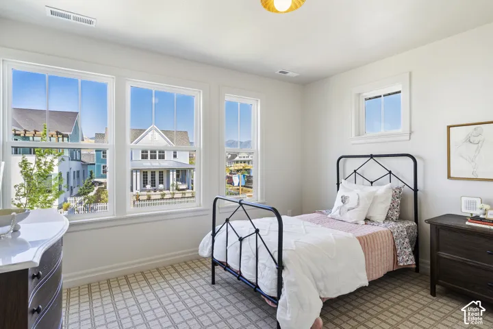 Multiple windows, recessed lighting, patterned carpet, white walls, and a ceiling-mounted light fixture