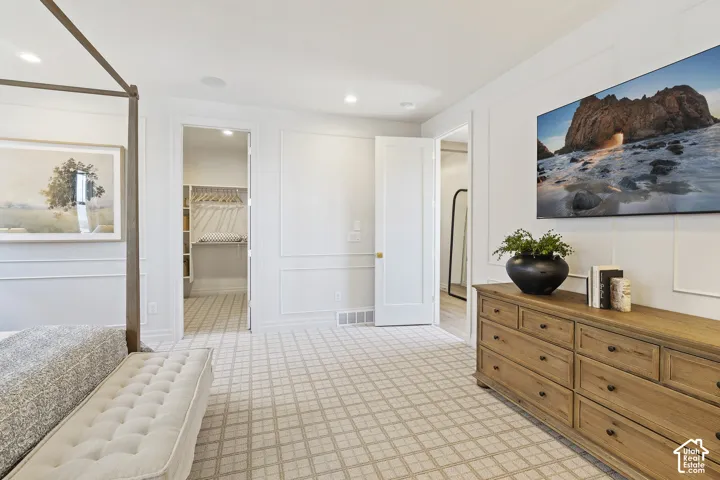 Wall paneling, recessed lighting, patterned carpeting, built-in closet system, and a solid wood dresser with multiple drawers