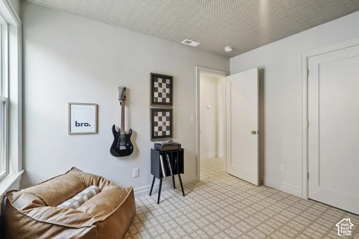 Patterned carpeting, neutral wall finishes, white trim, recessed ceiling detail, and a paneled interior door