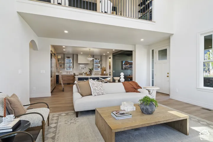 Expansive great room with vaulted ceilings, wood-finish flooring, and an open-concept kitchen