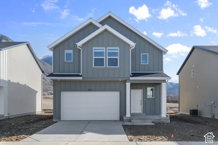 Two-story residence featuring board and batten siding, multiple gables, an attached garage, and a covered entry